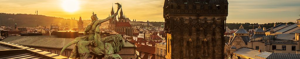 Pohled ze střechy budovy České národní banky na sochu světlonoše a Staré město pražské.